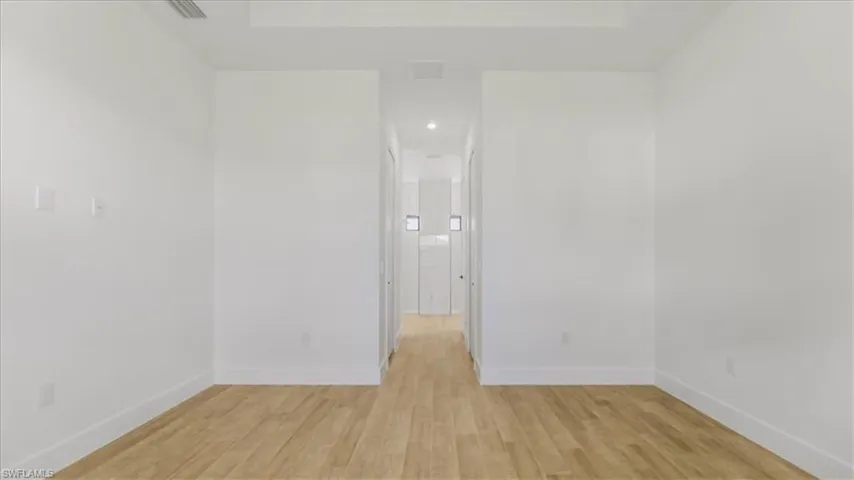 Unfurnished room with light wood-style floors and baseboards