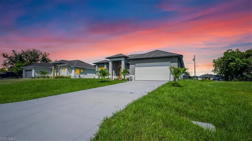 Prairie-style home featuring a front yard, concrete driveway, a garage, and stucco siding
