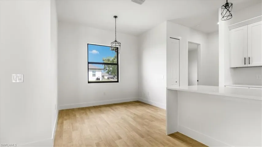 Unfurnished dining area featuring light wood-style floors and baseboards