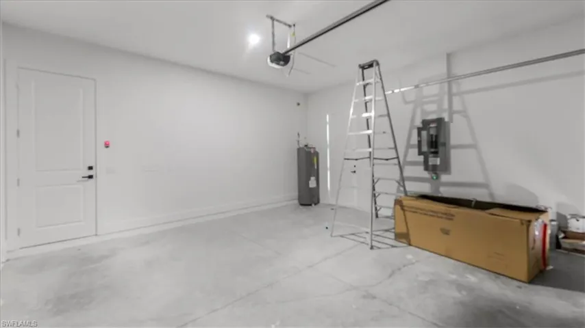 Garage featuring water heater and electric panel