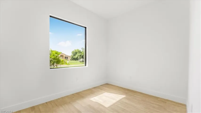 Unfurnished room featuring light wood finished floors and baseboards