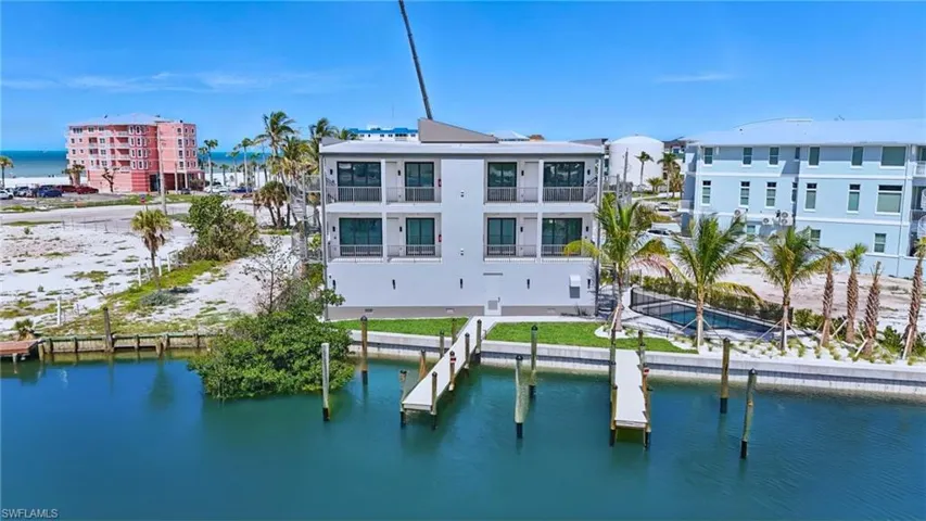 Modern multi-story structure with multiple private balconies and direct water access - Virtually Edited Image