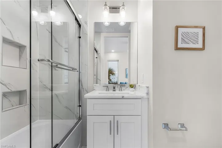 Bathroom featuring a single vanity with a white countertop and under-mount sink - Virtually Edited Image