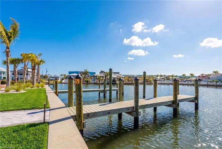 Waterfront concrete walkway bordered by manicured lawn and mature palm trees - Virtually Edited Image