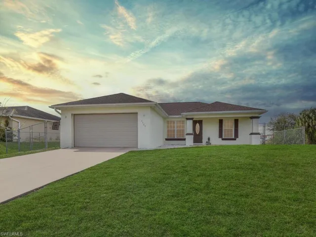 Single story home featuring a garage and a yard