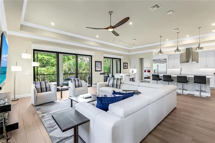 Living room with ceiling fan, a healthy amount of sunlight, and light wood-type flooring