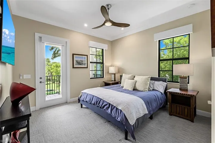 Bedroom with carpet flooring, access to exterior, and multiple windows