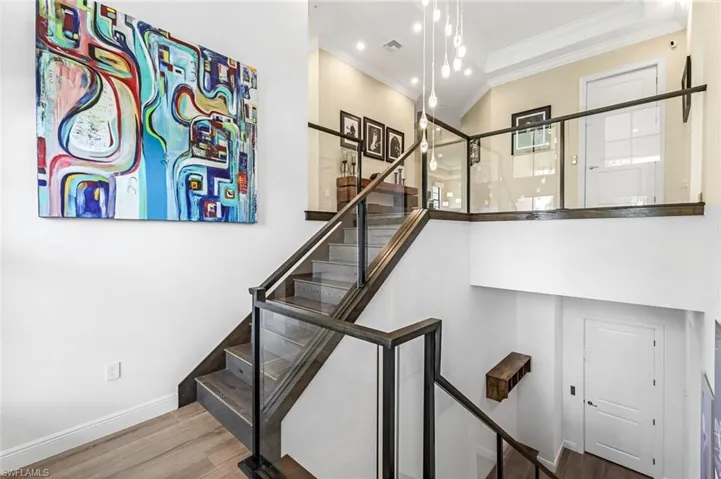 Staircase featuring crown molding and wood-type flooring