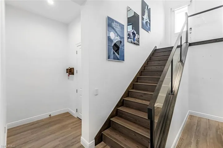 Stairs featuring hardwood / wood-style flooring
