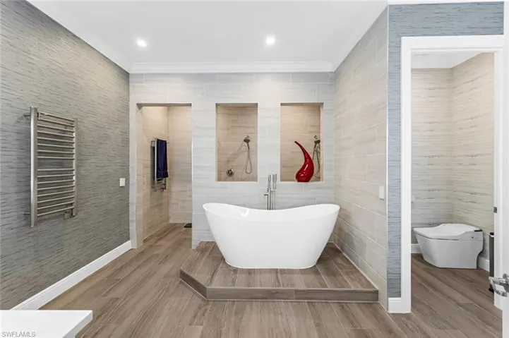 Bathroom with separate shower (dual heads) and tub, heated towel racks, toilet enclosed water room.