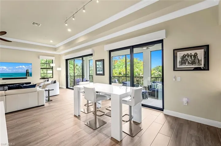 Dining space with ceiling fan, light hardwood / wood-style flooring, and track lighting
