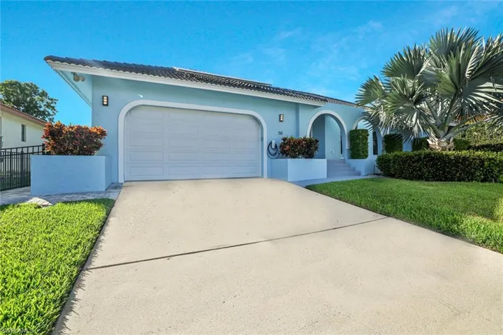 Mediterranean / spanish-style house featuring concrete driveway, stucco siding, an attached garage, and a front lawn