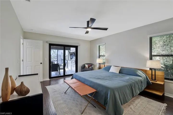 Bedroom with dark wood finished floors, access to outside, and a ceiling fan