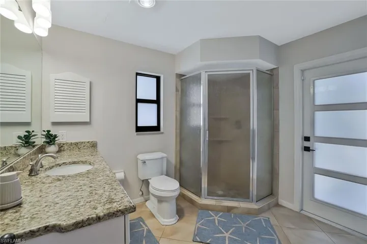 Bathroom featuring vanity, a shower stall, and light tile patterned flooring