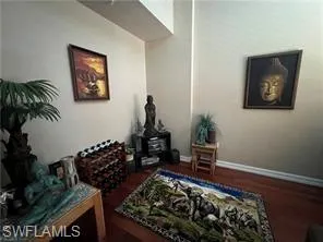 Sitting room featuring baseboards and dark wood-style floors