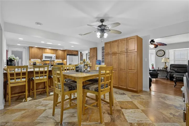 Dining room featuring ceiling fan, light stone finish floors, and recessed lighting