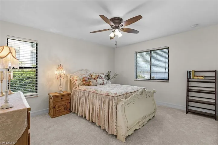 Bedroom #4 with baseboards, a ceiling fan, light carpet, and multiple windows with River view and walk in closet