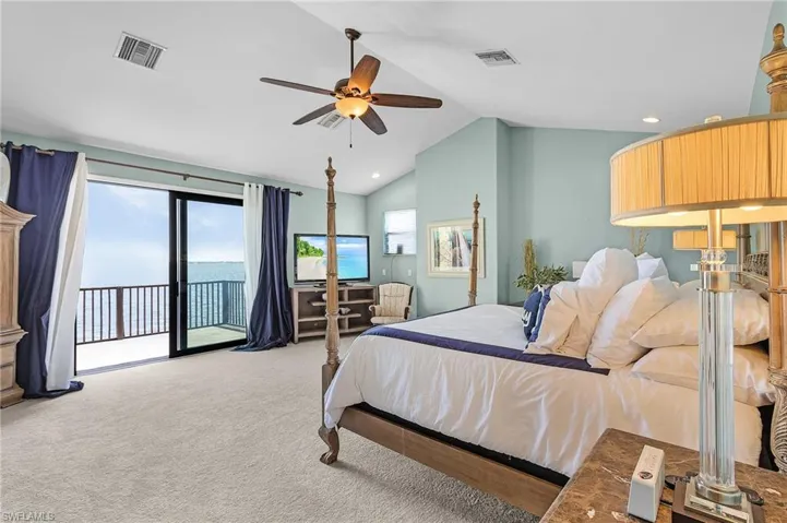 Primary upstairs ensuite bedroom ,  featuring new carpet , cathedral ceiling, ceiling fan, access to deck, and huge walk in closet