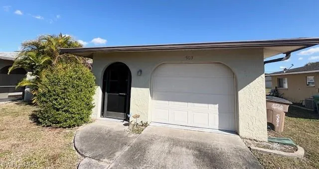 Doorway to property with stucco siding and a garage