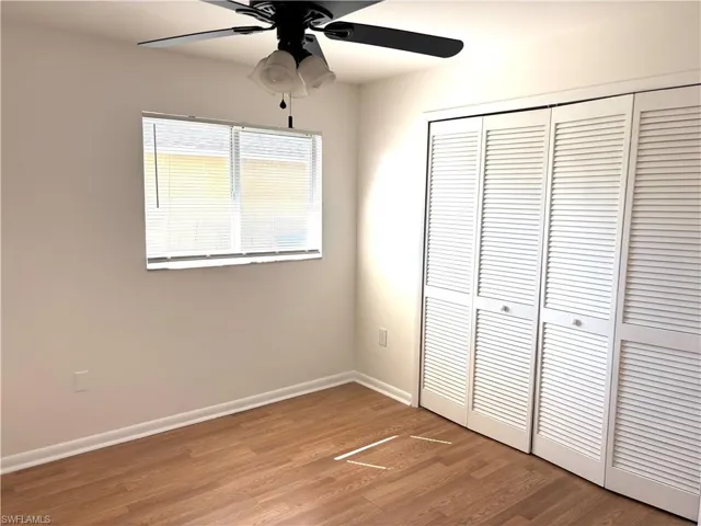 Unfurnished bedroom featuring wood finished floors, ceiling fan, and a closet