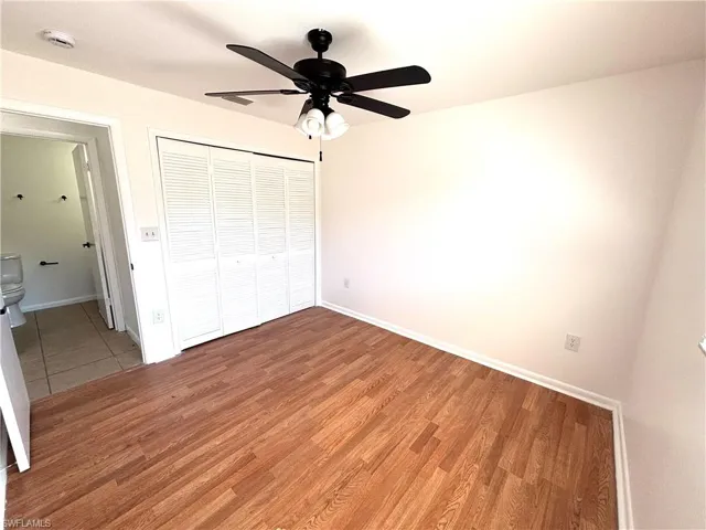 Unfurnished bedroom featuring light wood-style flooring, a closet, and a ceiling fan