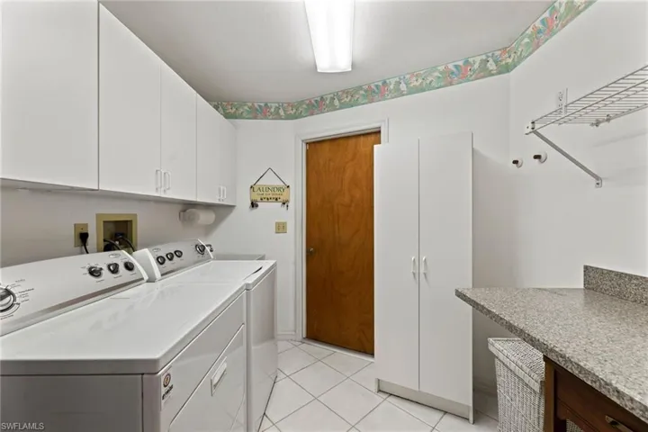 The large laundry room comes with washer & dryer, cabinets above, laundry tub sink, pantry closet, ironing board and folding counter top