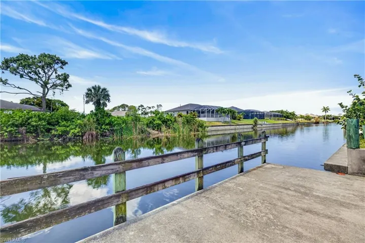 Waterfront property featuring a concrete boat ramp and wood-plank railing