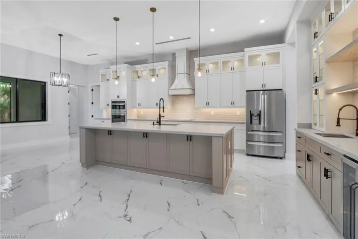 Kitchen featuring stainless steel appliances, a large island with sink.