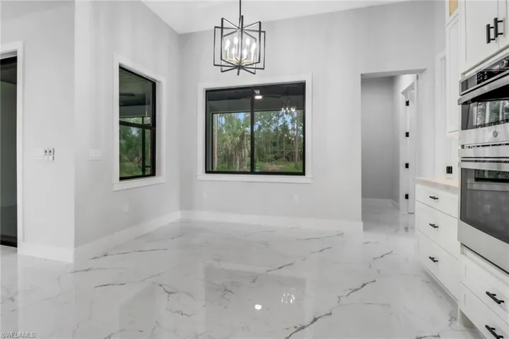 Unfurnished dining area with light tile patterned flooring and an inviting chandelier