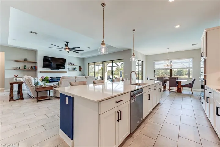 Kitchen with an oversized island, dining area, wall oven and quartz countertops