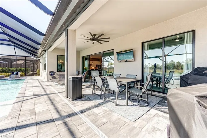 View of patio / terrace with screened enclosure, outdoor dining space, a ceiling fan, and an outdoor pool