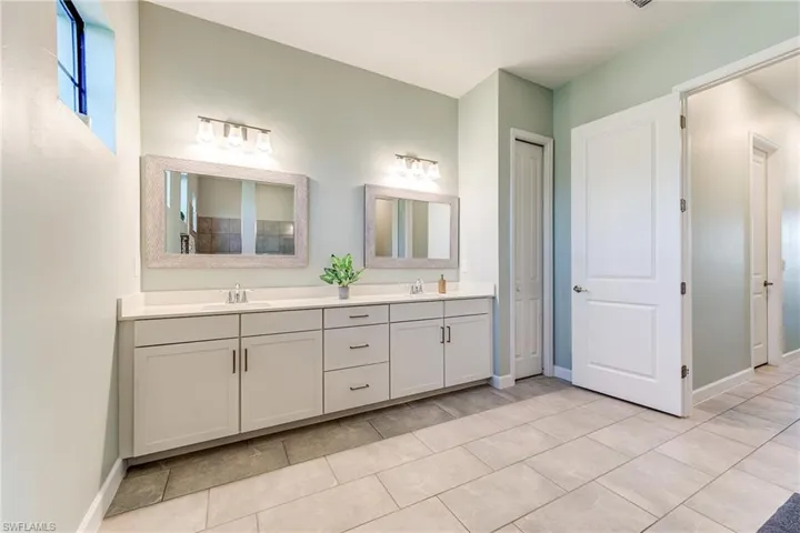 Primary Bathroom with quartz countertops, dual sinks and walk in shower