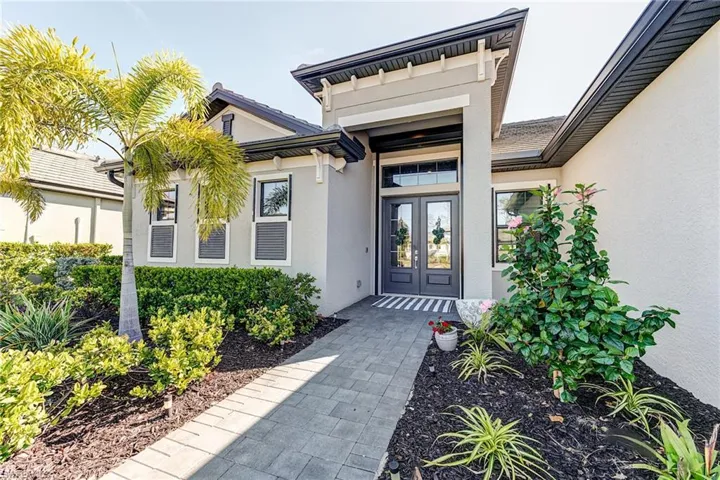 View of exterior entry featuring french doors and stucco siding