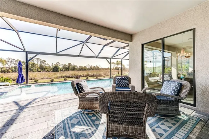 One View of patio / terrace featuring screened pool enclosure ,outdoor pool, spa and electric storm shutters to close in patio