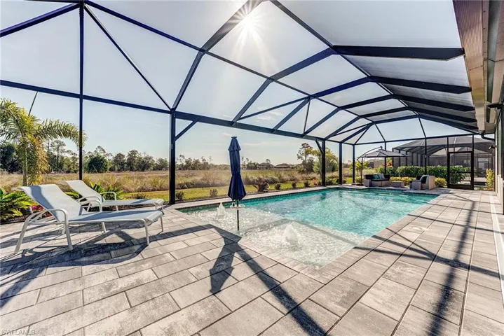 Outdoor pool with a lanai and a patio