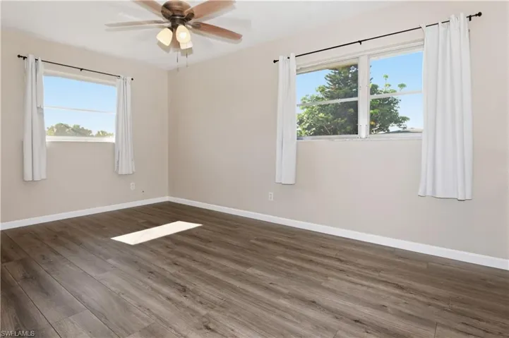 Spare room featuring dark wood-style flooring and ceiling fan