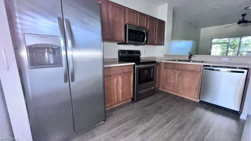 Kitchen featuring wood-finish flooring, stainless steel appliances, and wood cabinetry