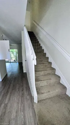 Staircase with carpeted treads and white wood balusters