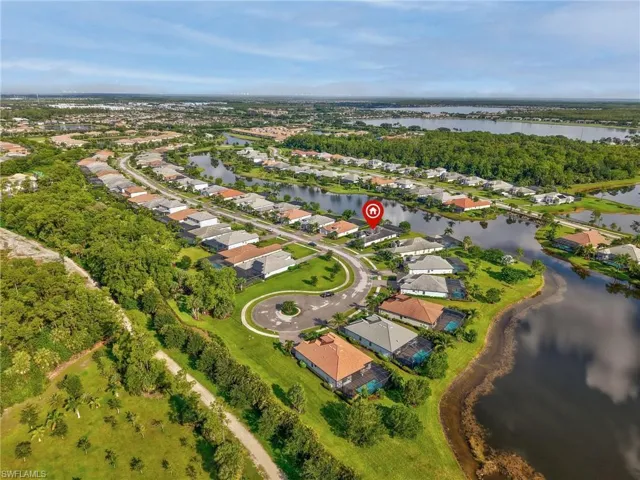 Aerial view of property and surrounding area with nearby suburban area and a large body of water