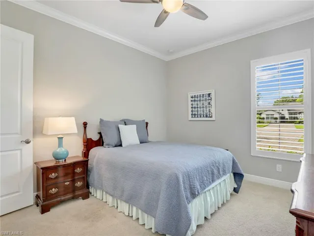 Bedroom featuring ornamental molding, carpet flooring, and a ceiling fan