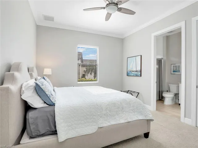 Bedroom featuring crown molding, light colored carpet, ceiling fan, and connected bathroom