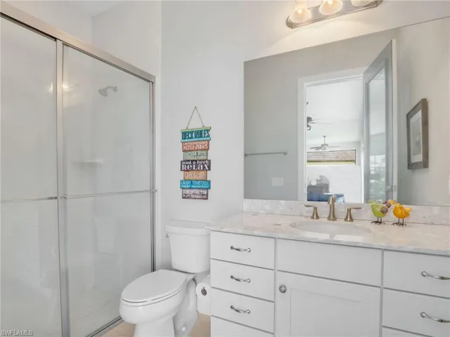 Full bathroom featuring vanity, a stall shower, and ceiling fan