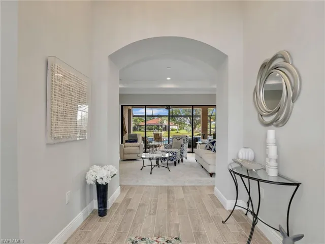 Hall featuring wood tiled floors, arched walkways, and recessed lighting