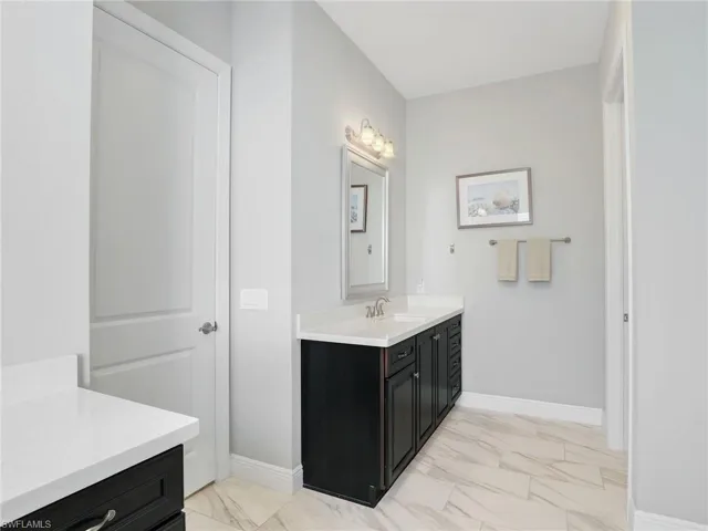 Full bathroom featuring light marble finish floors and vanity