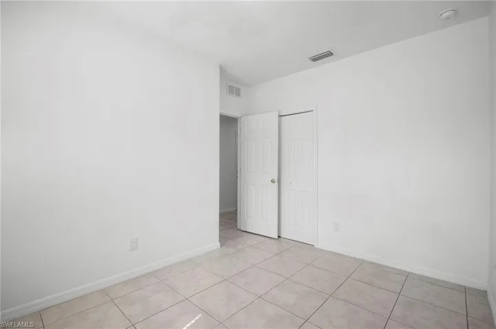 Unfurnished bedroom with a closet and light tile patterned floors