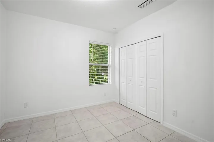 Unfurnished bedroom with light tile patterned flooring and a closet