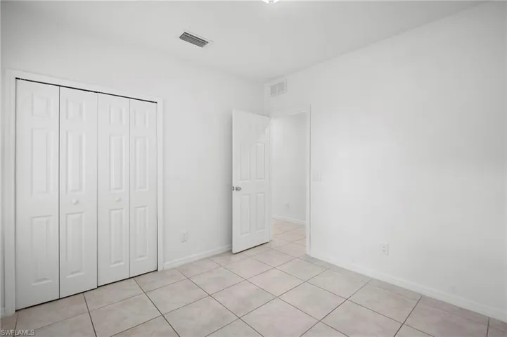 Unfurnished bedroom with a closet and light tile patterned flooring