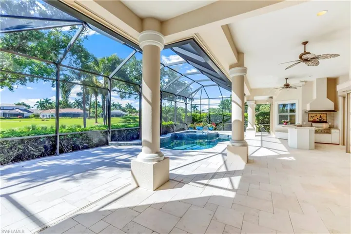 Large limestone pool deck with wrap-a-round  overhang