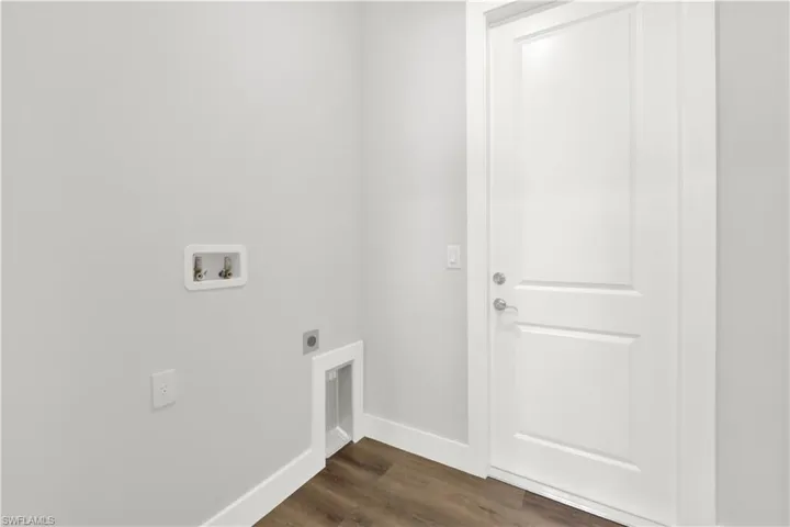 Clothes washing area featuring hookup for a washing machine, dark hardwood / wood-style flooring, and hookup for an electric dryer