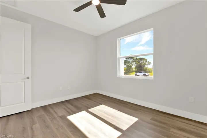 Empty room featuring ceiling fan and hardwood / wood-style flooring